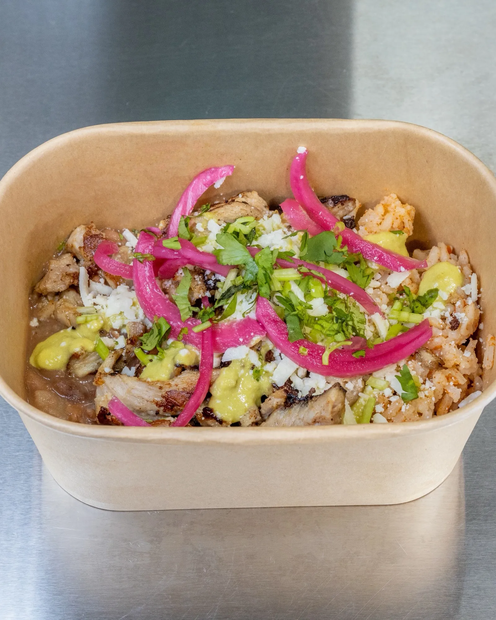 Carnitas bowl with pickled red onion, cilantro and avocado salsa